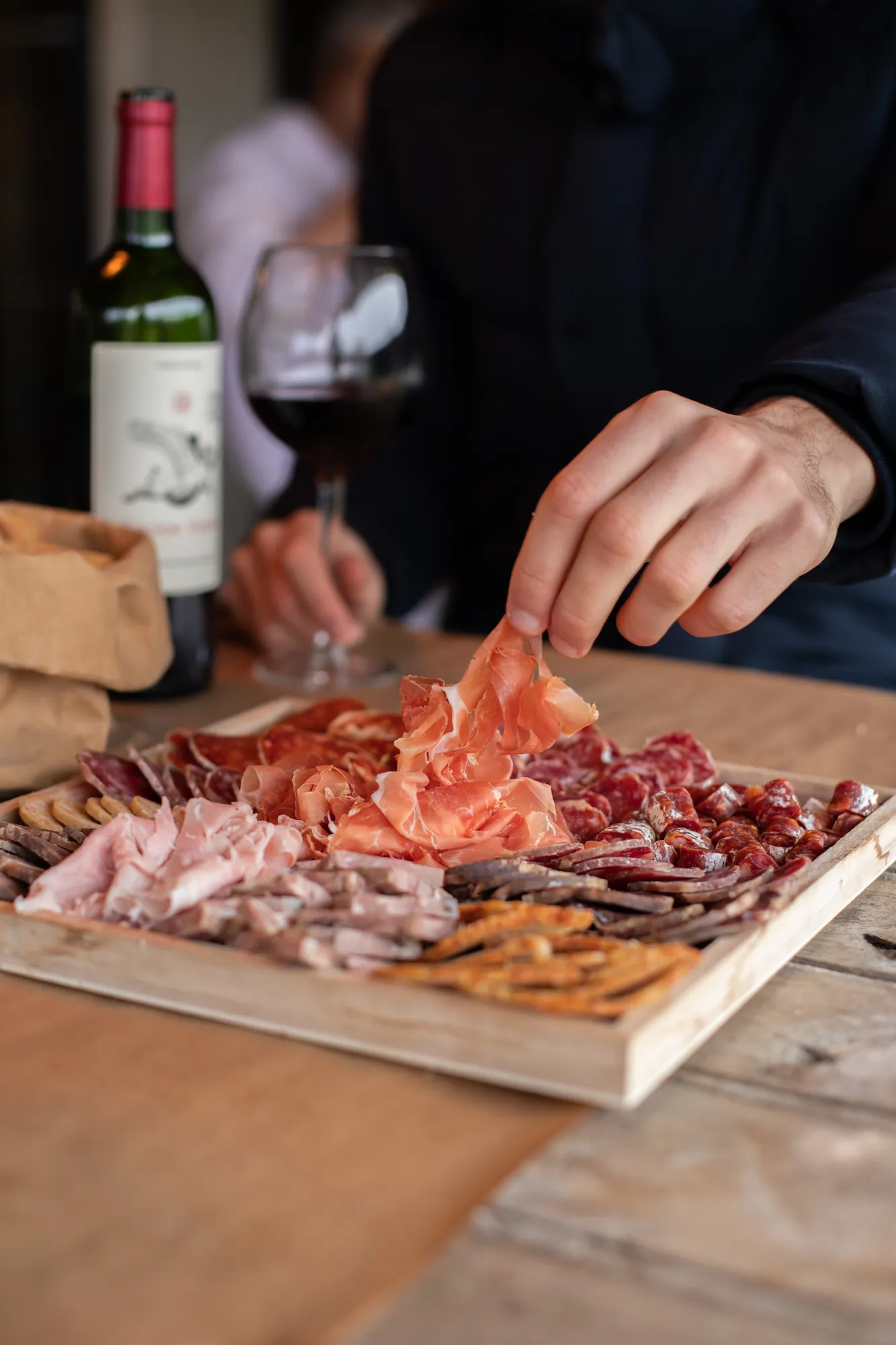 Une planche de charcuterie Millas et un verre de vin