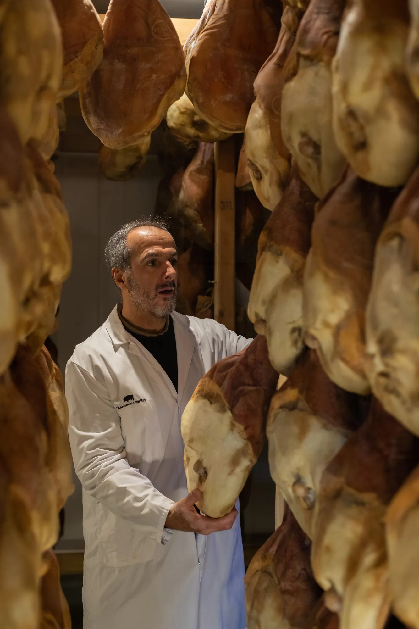 Akim au séchoir, un jambon dans les mains